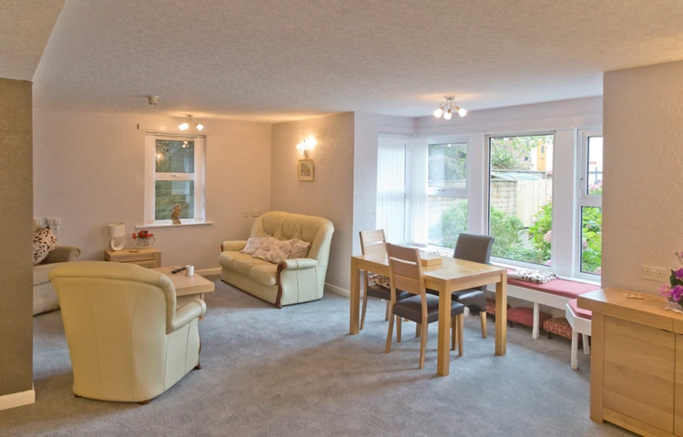 A bright cosy lounge area with seating areas for residents