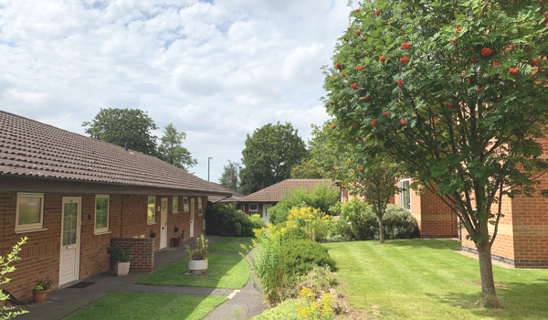 Garden path through sunny gardens at The Firs Complex