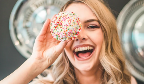 Woman Holding Up Doughnut Over Eye