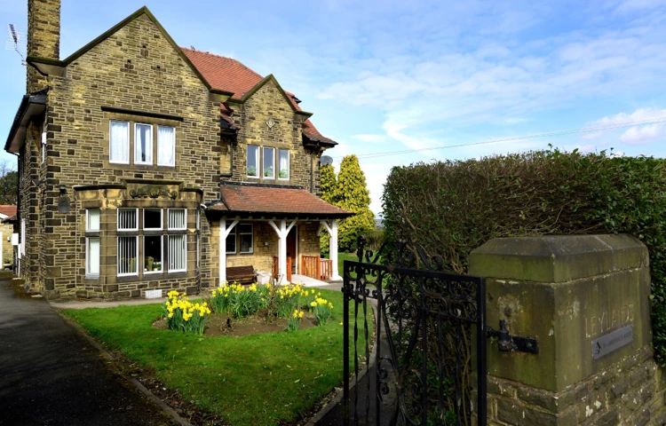 The front of a grand stone house with a porch at Leylands Lane, Bradford BD9 5QU