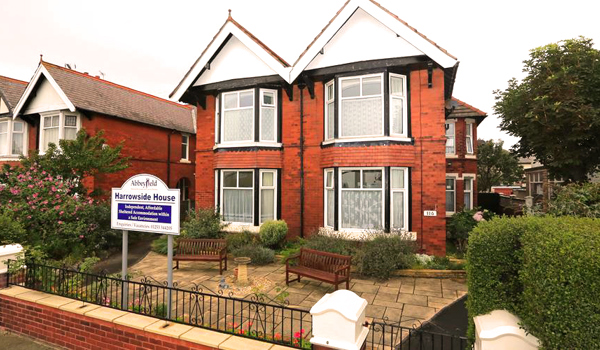 Large red brick house with two benches at the front