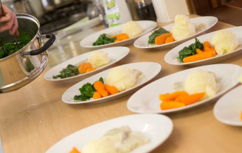 The house chef is plating up dinner for the residents
