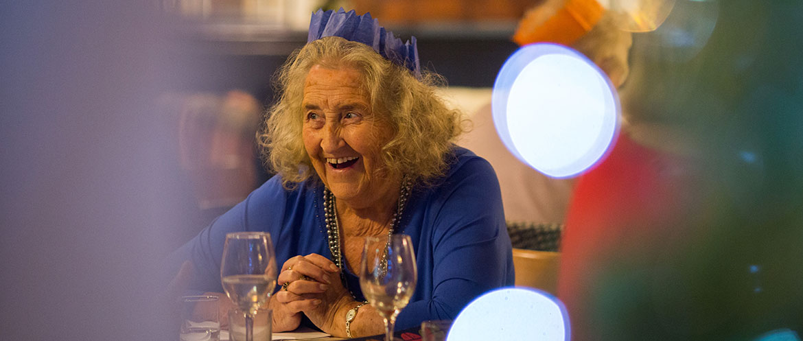 Older lady smiling at Christmas dinner