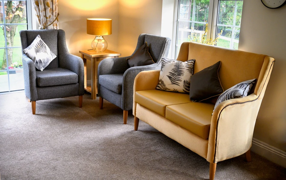 A modern lounge area with grey chairs and yellow sofa