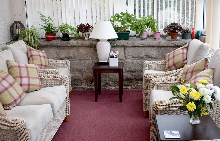 The conservatory area with a sofa and chairs